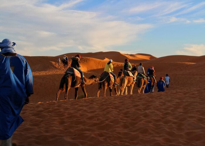 Children riding camels in the golden Sahara Desert during Morocco family holiday package morocco