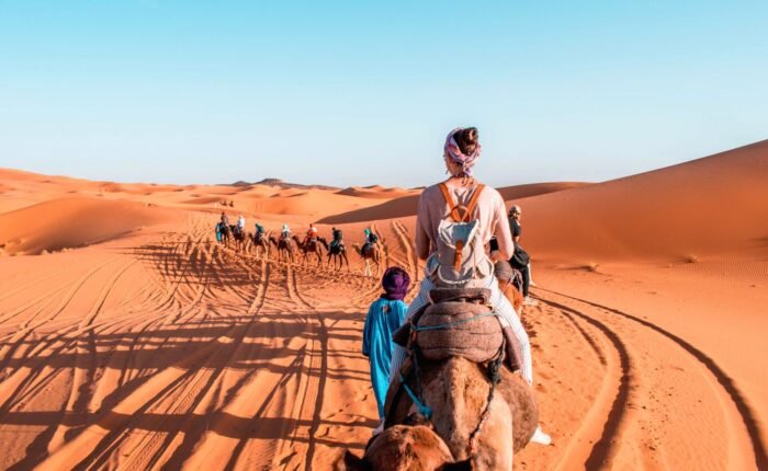 Morocco Desert Tour – camel trekking in Sahara desert dunes at sunset”