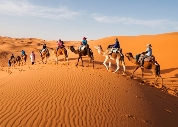Family riding camels in the Sahara Desert during a Morocco travel package