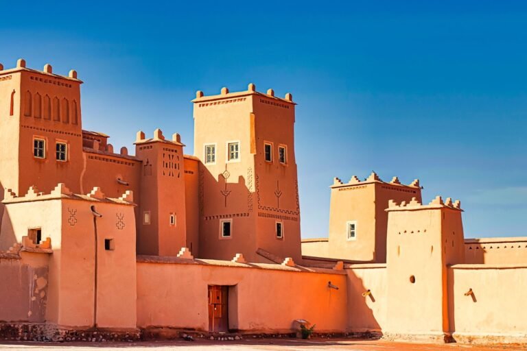 A stunning view of a traditional Moroccan fortress with distinct architectural features against a bright blue sky. dallas to moroccco